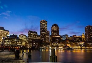 A vibrant evening view of New York City’s illuminated skyline reflecting off the Hudson River, symbolizing the city’s resilient tech spirit. As global headwinds persist, NYC’s startup ecosystem continues to surge, with bright innovation hubs lighting the path forward in 2025.